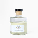 Clear glass bottle with a black cap and white label on a white background