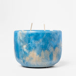 Blue and beige marbled candle on a white background
