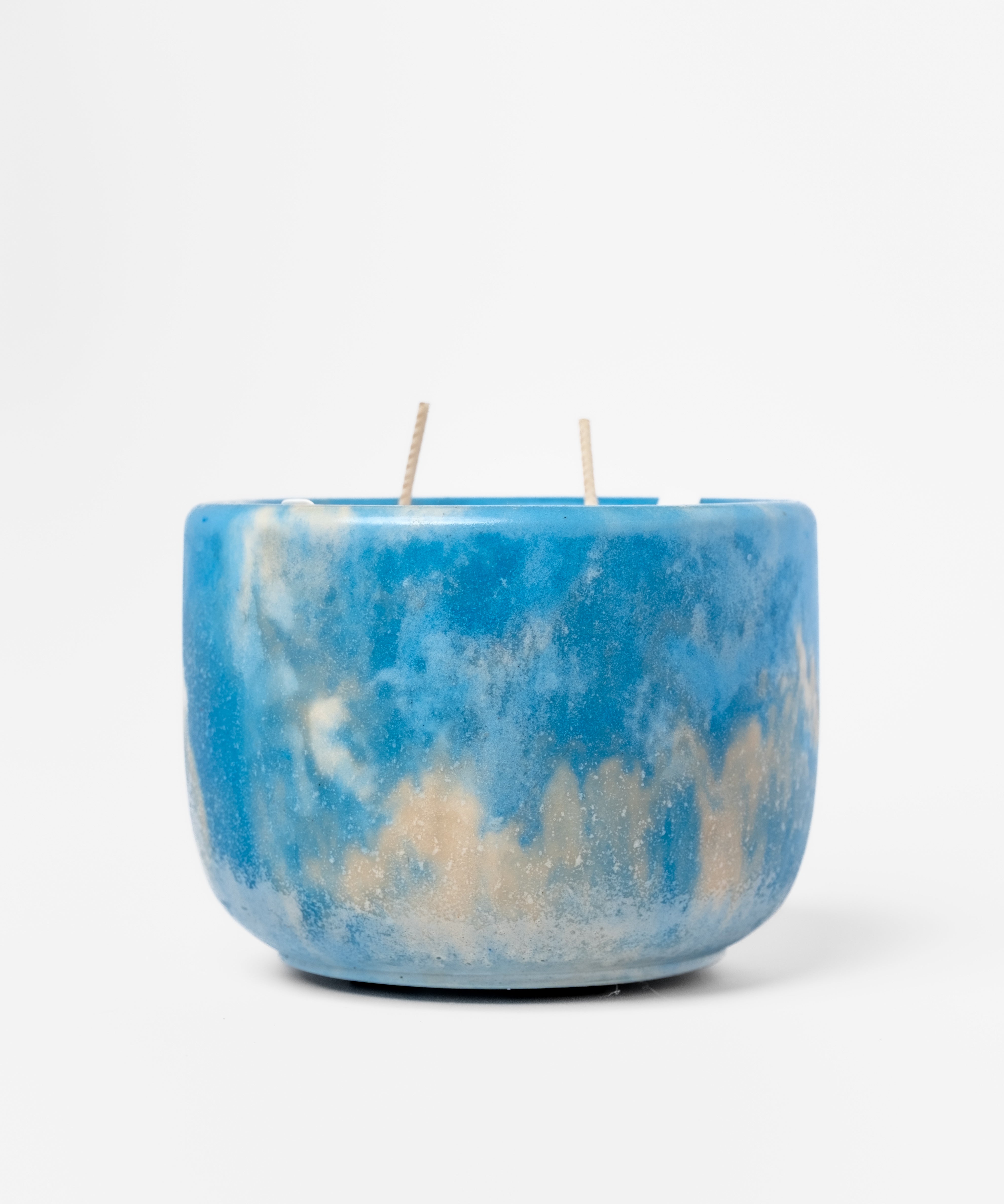 Blue and beige marbled candle on a white background