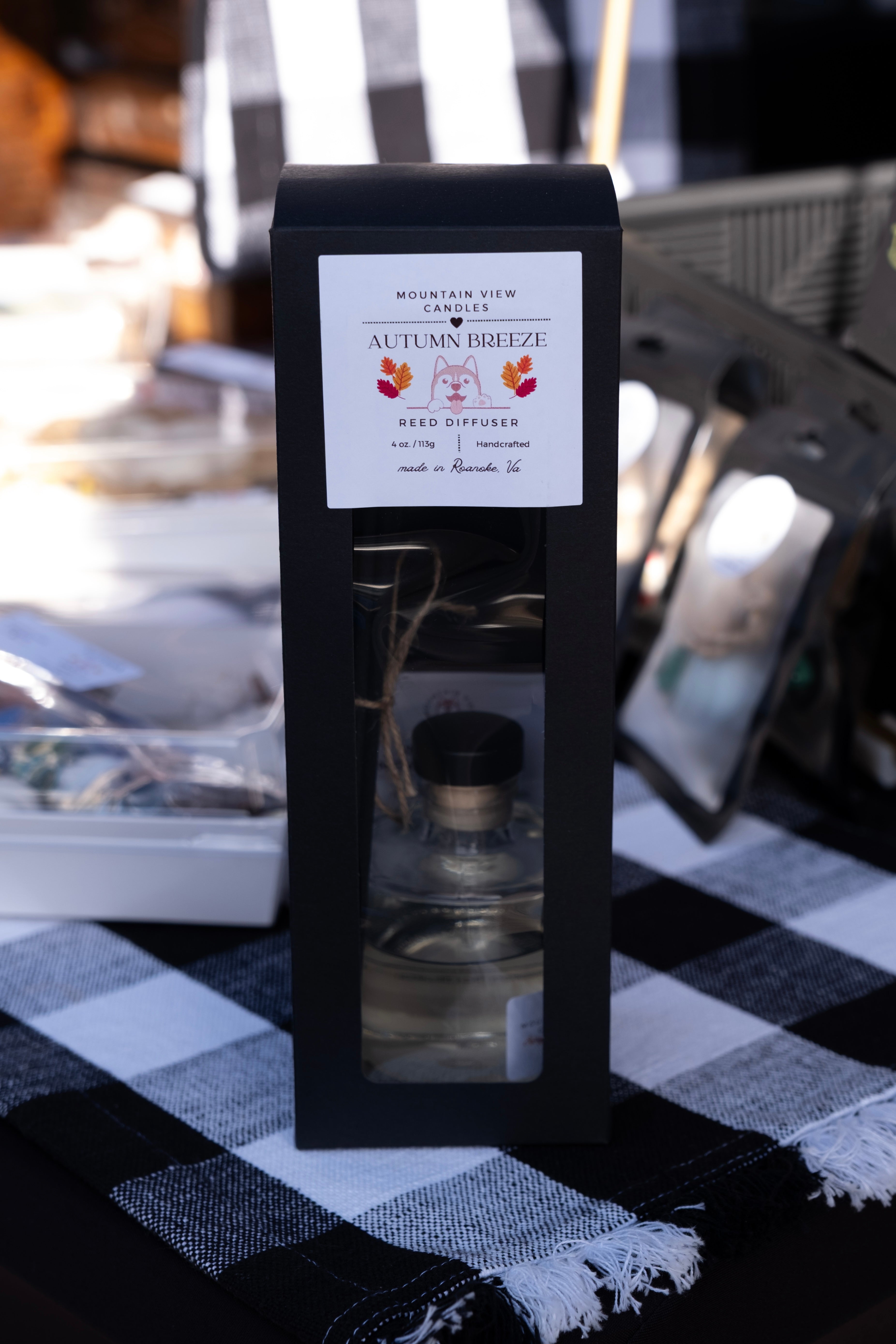 Mountain View Candles Autumn Breeze Reed Diffuser packaging on a checkered tablecloth