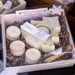 Gift set with candles, soap, and other items in a box labeled 'Winter Collection'.