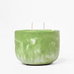 Green marbled candle with two wicks on a white background