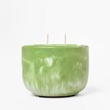 Green marbled candle with two wicks on a white background