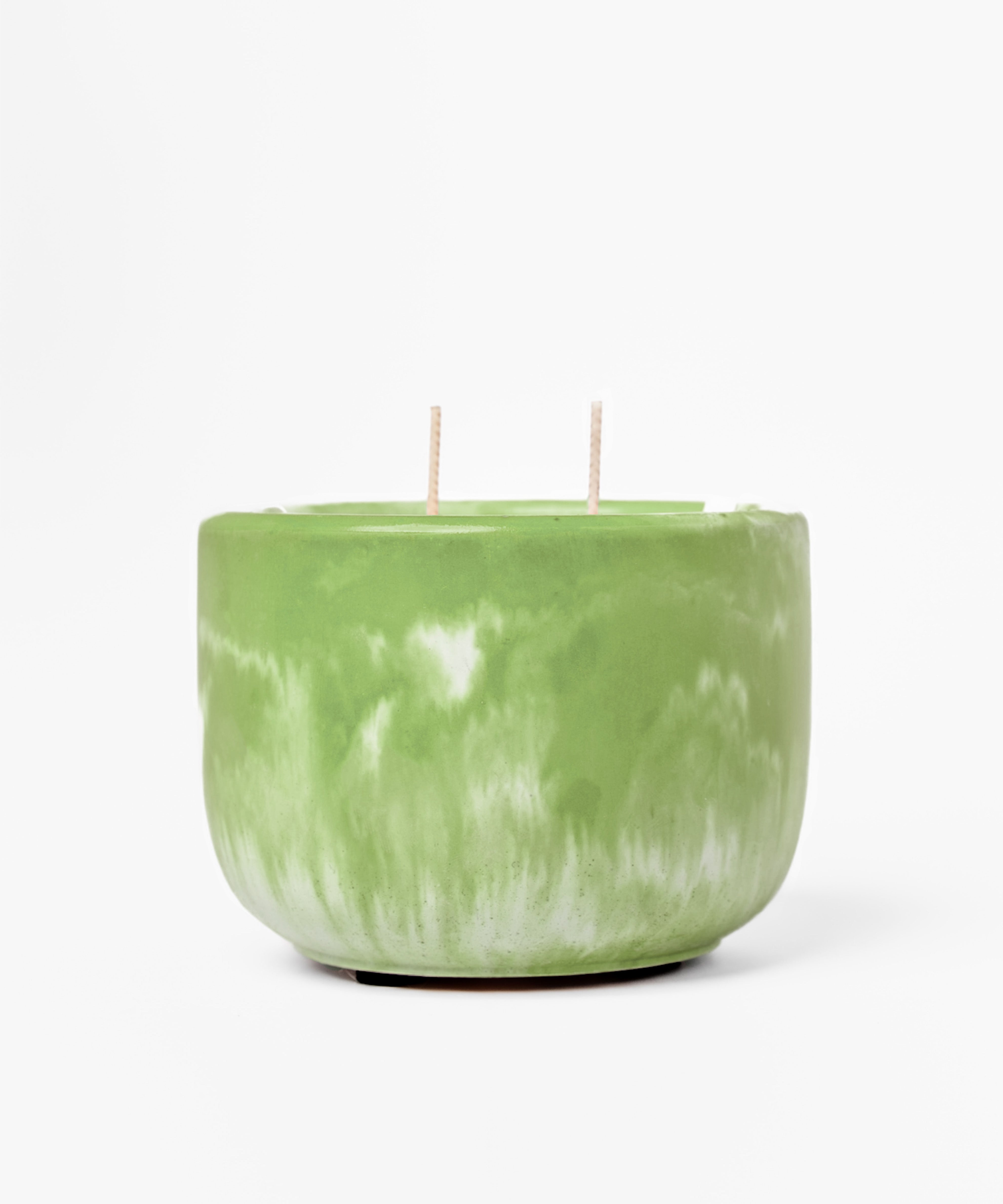 Green marbled candle with two wicks on a white background