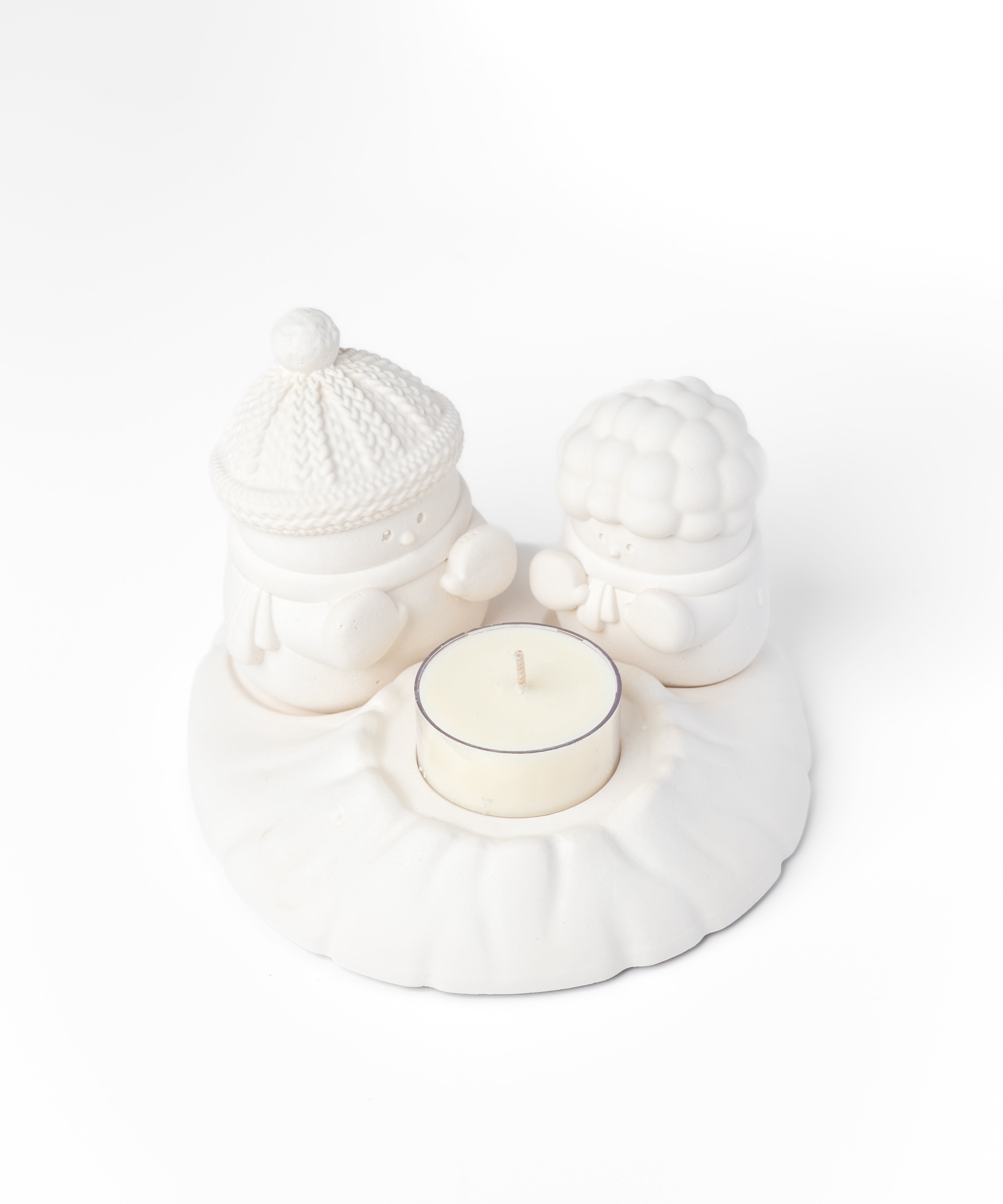 White ceramic holder with a small candle on a white background