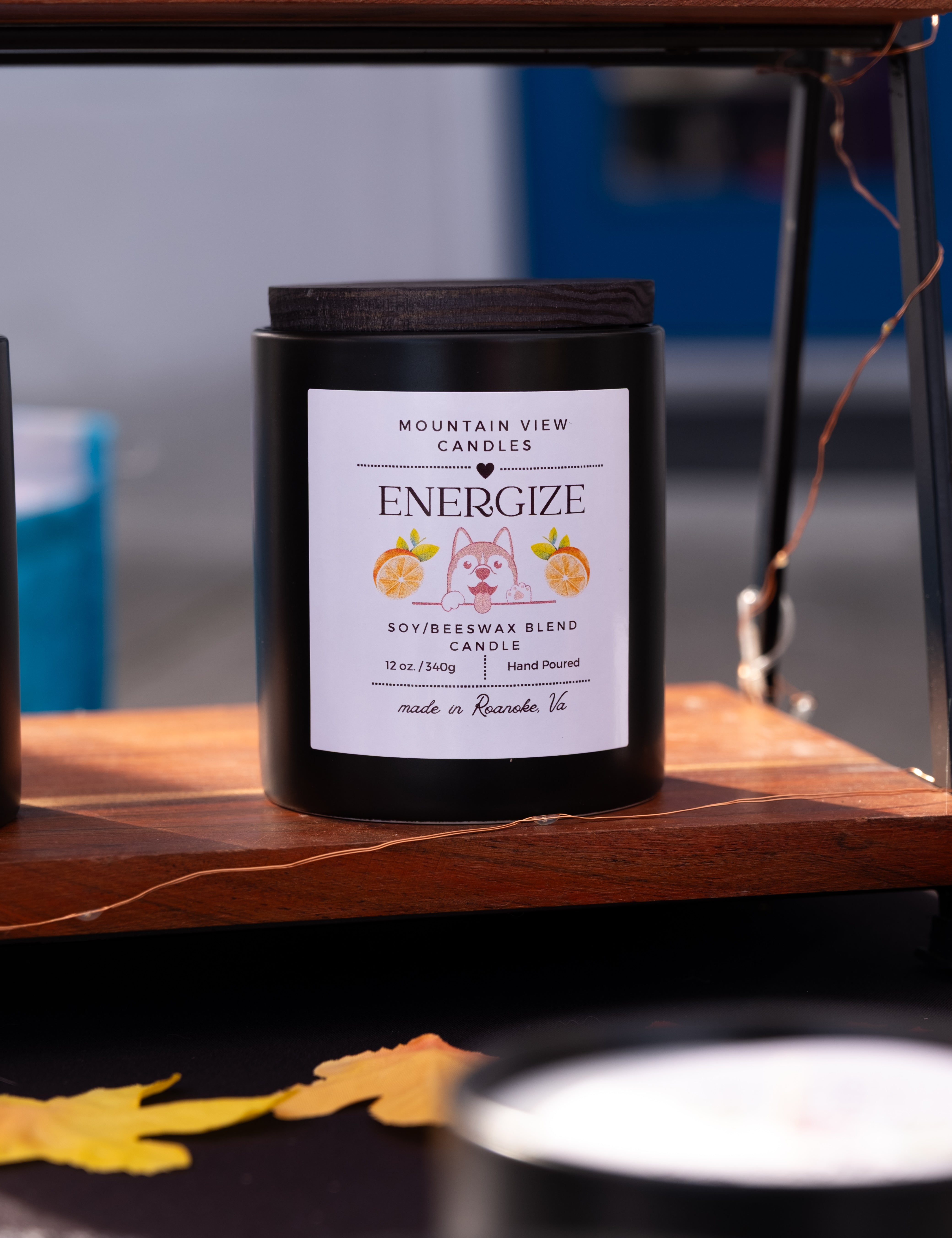 Candle labeled 'Energize' by Mountain View Candles on a wooden surface.