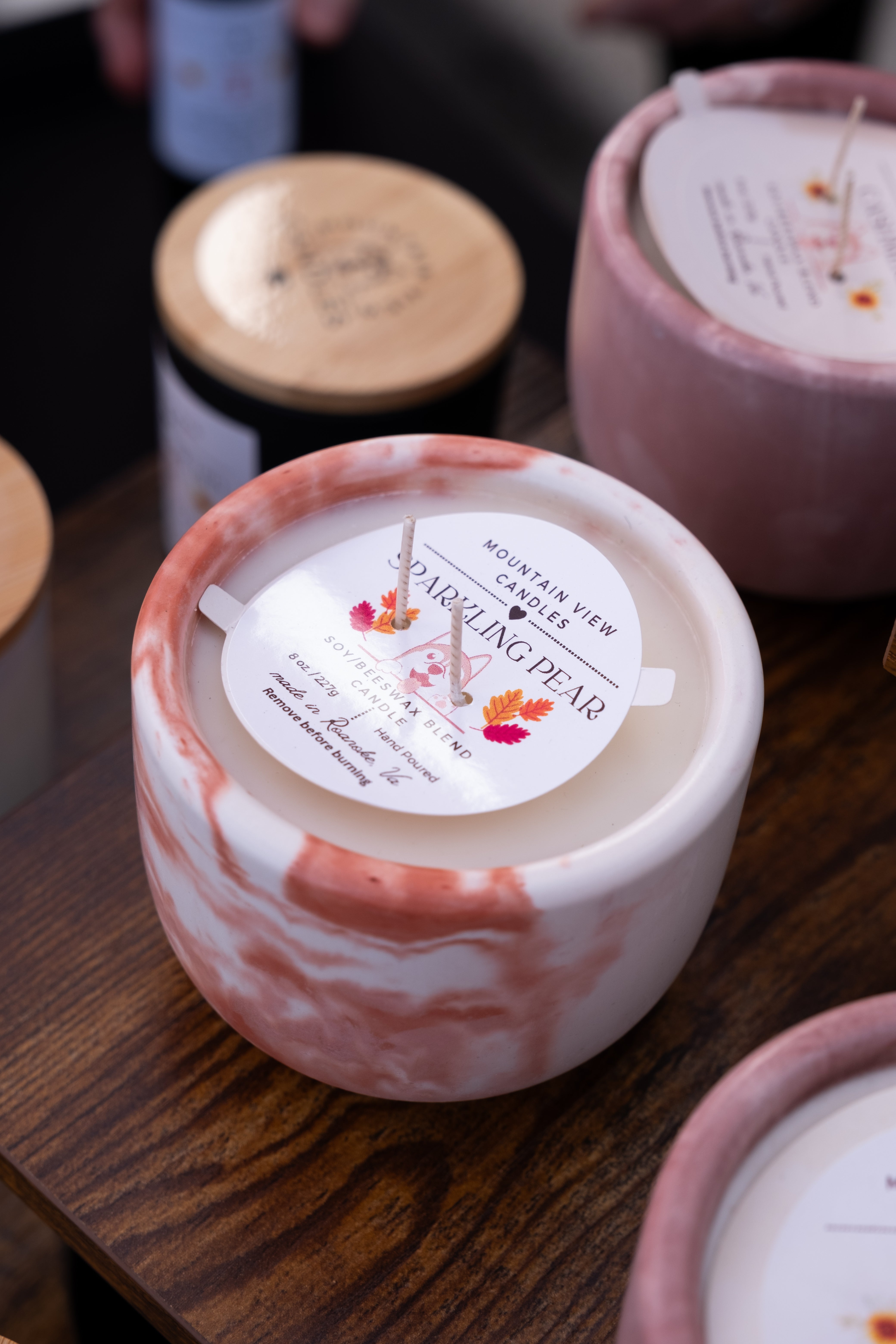 Candle with a label on a wooden surface