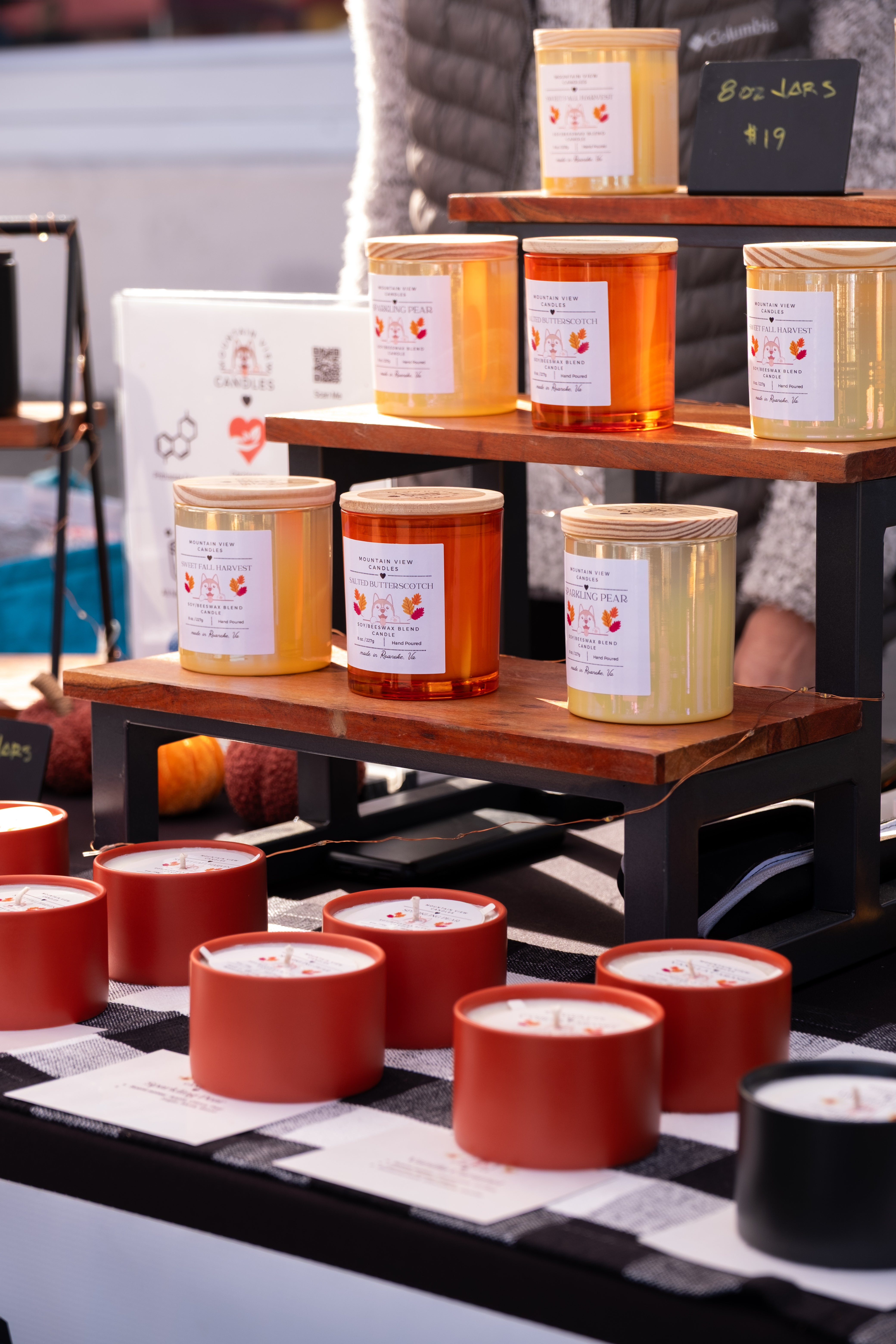 Assorted candles on display with a checkered tablecloth