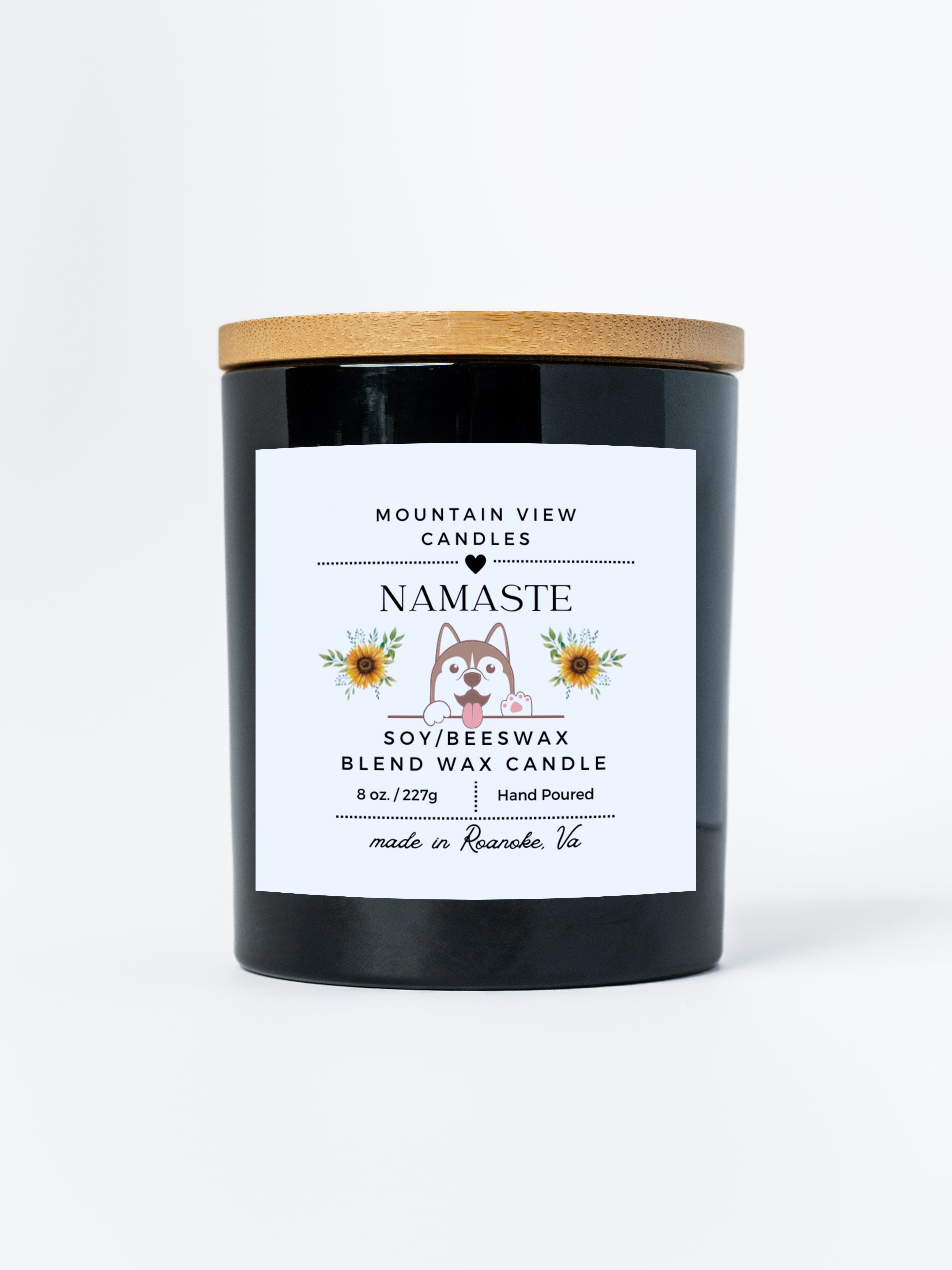 Black candle with a wooden lid and 'Namaste' label on a white background