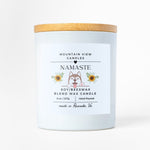 Candle with a wooden lid and 'Namaste' label on a white background