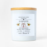 Candle with a wooden lid and 'Namaste' label on a white background