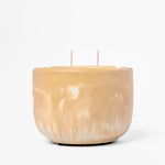 Tan marbled candle with two wicks on a white background