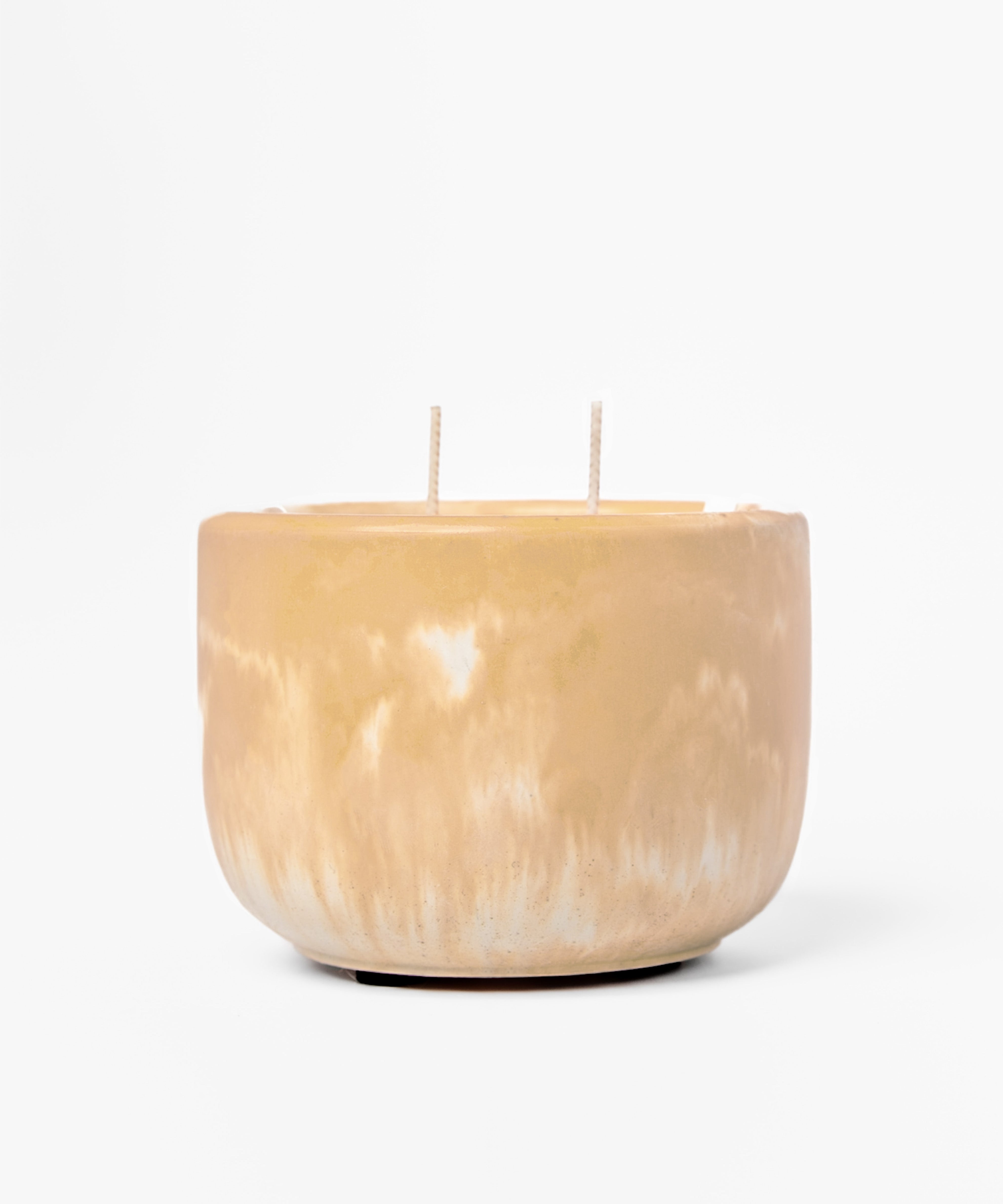 Tan marbled candle with two wicks on a white background