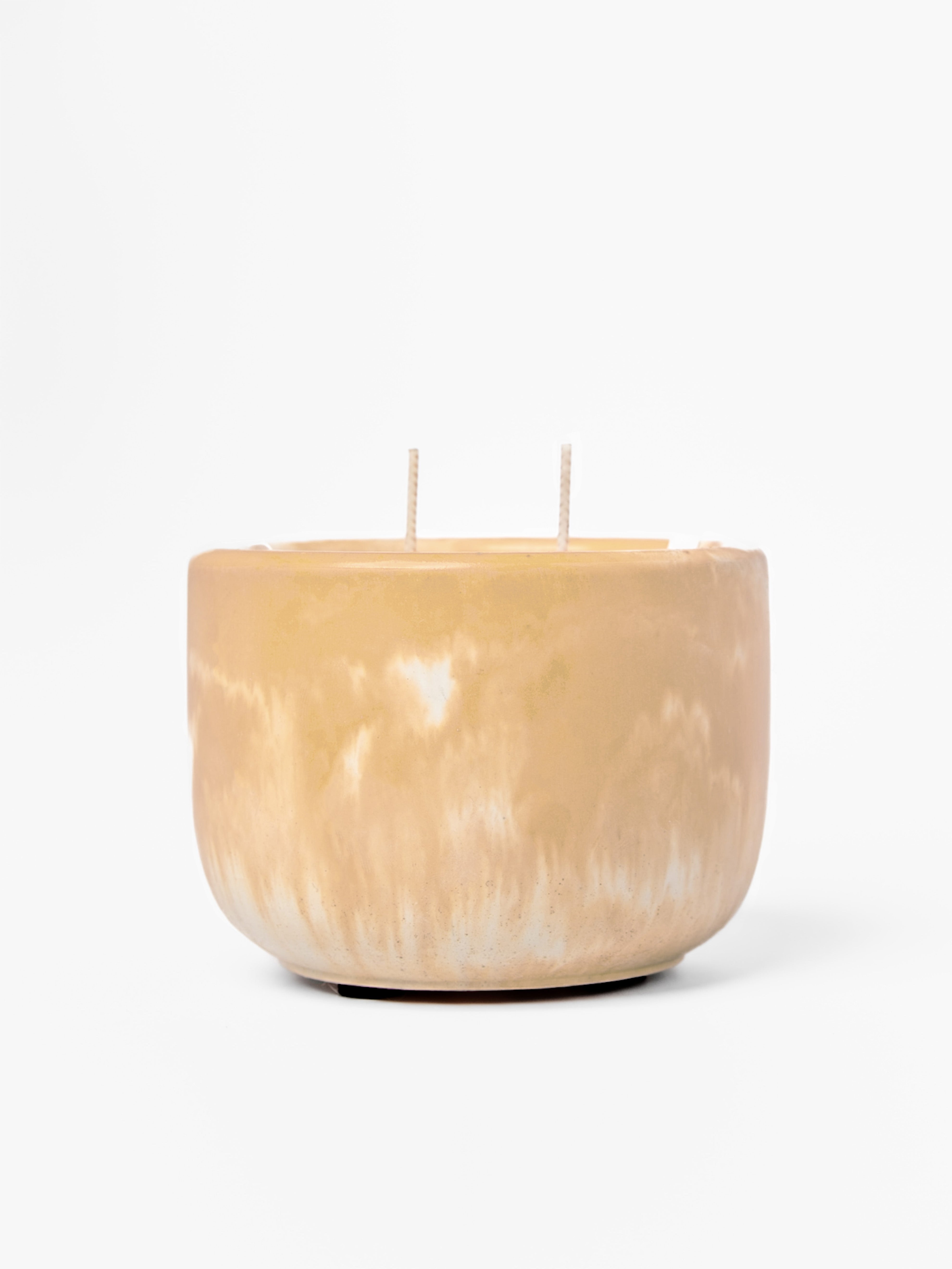 Tan marbled candle with two wicks on a white background
