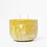 Yellow marbled candle with two wicks on a white background