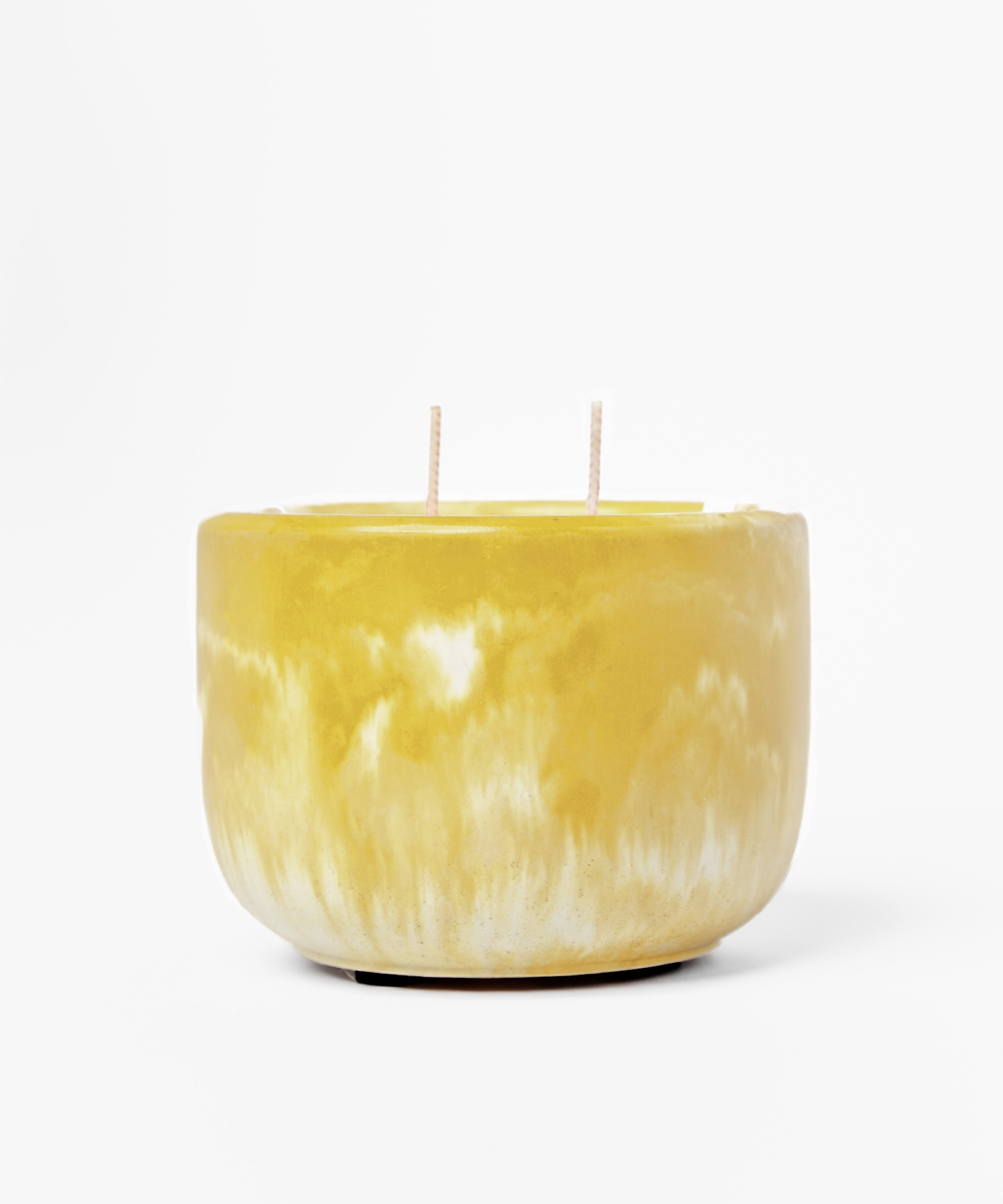 Yellow marbled candle with two wicks on a white background