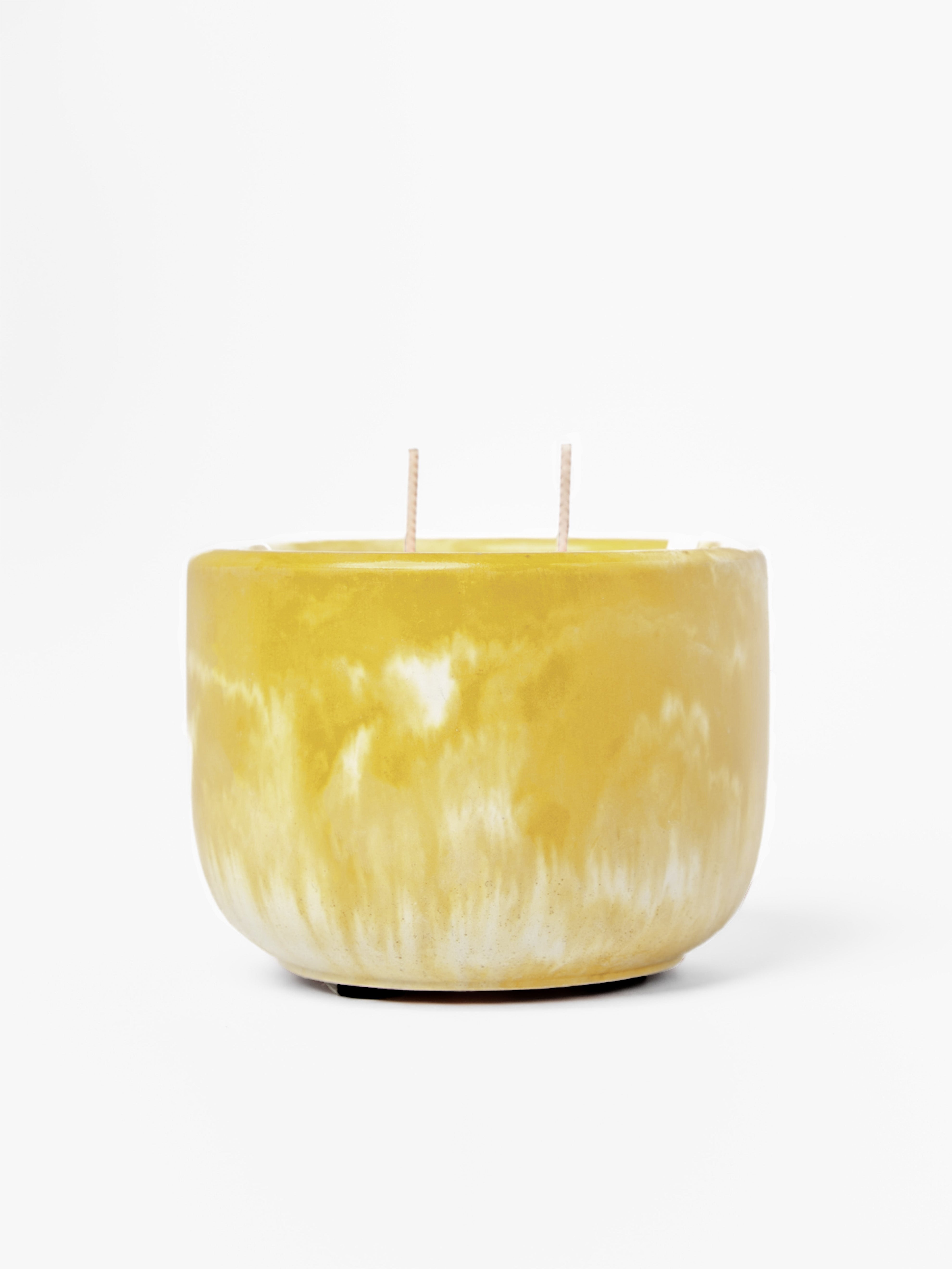 Yellow marbled candle with two wicks on a white background