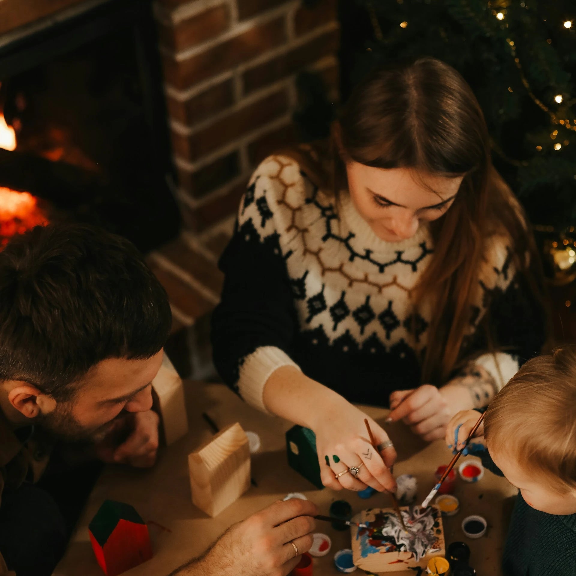 Family gathered around a Christmas tree, working on puzzle pieces.