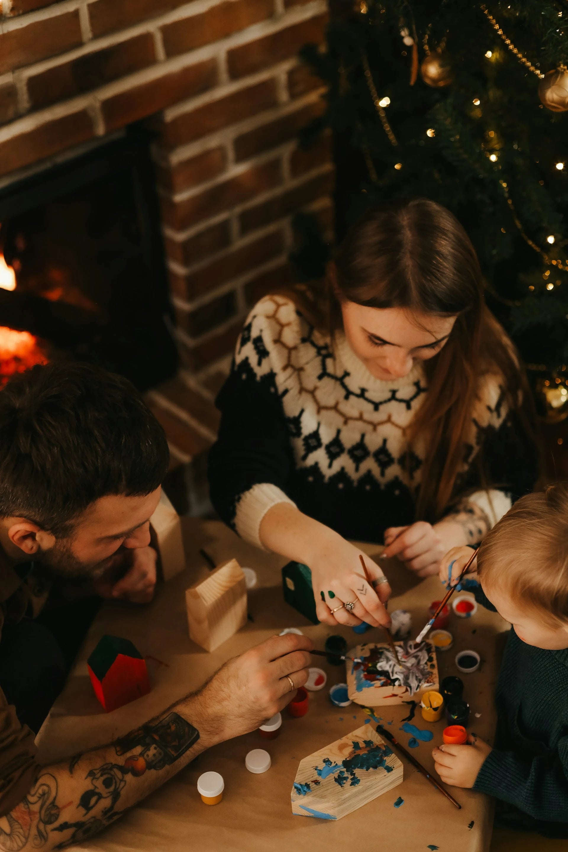 Family gathered around a Christmas tree, working on puzzle pieces.